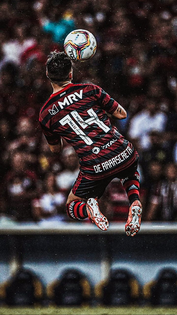 Jogador de futebol dominando a bola no ar durante partida